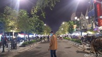 Para wisatawan dengan santai dan bebas berjalan dan foto-foto di tengah jalan tanpa khawatir. 