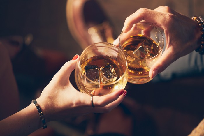 Minuman beralkohol A couple makes a toast with two glasses of whiskey