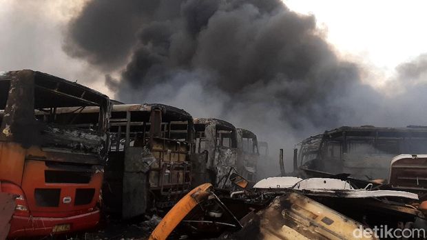 Kebakaran terjadi di lokasi penampungan bangkai bus Trans Jakarta di Desa Dramaga, Bogor. Puluhan bangkai bus nampak hangus terbakar.