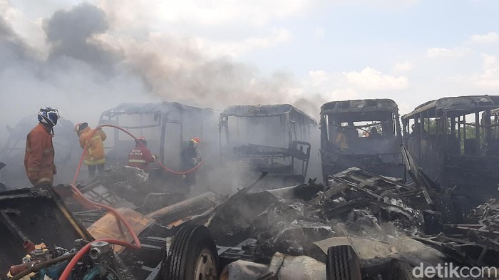Kebakaran terjadi di lokasi penampungan bangkai bus Trans Jakarta di Desa Dramaga, Bogor. Puluhan bangkai bus nampak hangus terbakar.