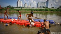 Di bantaran sungai, mereka bermain dengan kubus apung sebagai pembatas.