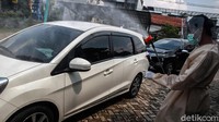 Mobil warga yang akan melakukan imunisasi juga disemprot disinfektan.