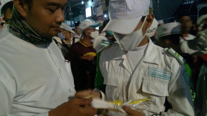 Laskar Pembela Islam (LPI) FPI membagikan masker kepada pengunjung acara Maulid Nabi Muhammad SAW, dan pernikahan putri Habib Rizieq di Petamburan.