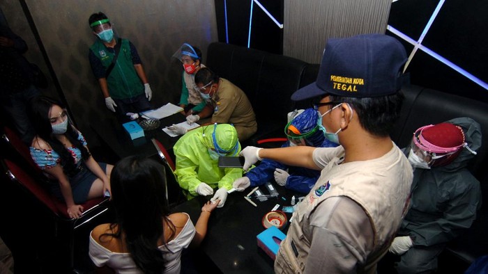 PEMERIKSAAN TES CEPAT DI TEMPAT HIBURAN MALAM Petugas kesehatan melakukan tes cepat (rapid test) kepada pekerja saat razia protokol kesehatan di tempat hiburan malam, Tegal, Jawa Tengah, Sabtu (14/11/2020) malam. Pemeriksaan protokol kesehatan dan rapid test oleh Dinas Kesehatan, Satpol PP dan TNI/Polri kepada pengunjung dan pekerja secara acak tersebut guna mengantisipasi penyebaran COVID-19 di tempat hiburan malam, akibat semakin meningkatnya kasus positif COVID-19 di Kota Tegal. ANTARA FOTO/Oky Lukmansyah/wsj.