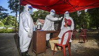 Petugas kesehatan dari EcoNusa Foundation memeriksa suhu warga yang diduga terpapar COVID-19 saat simulasi penanganan pasien terpapar COVID-19.