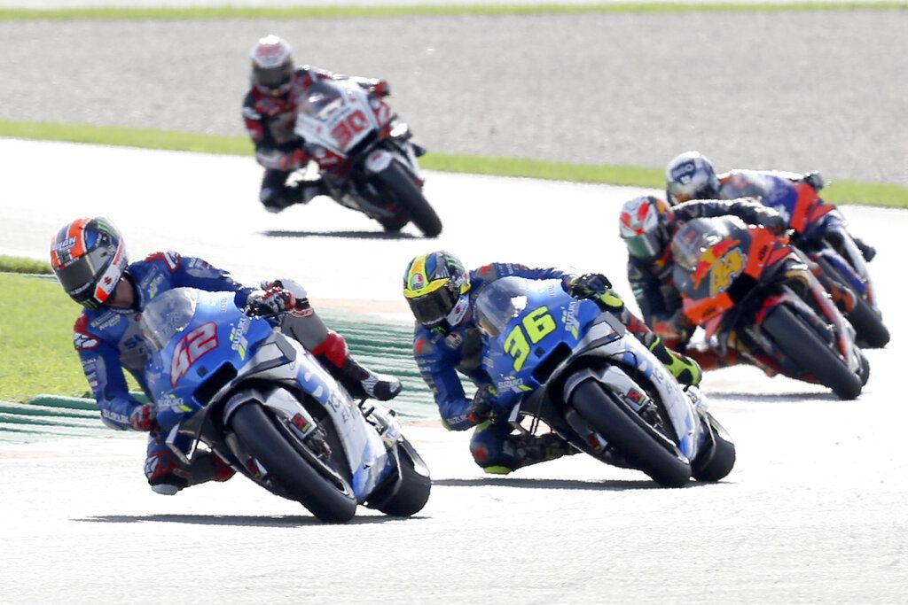Spain's rider Alex Rins of the Team SUZUKI ECSTAR leads on Spain's rider Joan Mir of the Team SUZUKI ECSTAR and Spain's rider Pol Espargaro of the Red Bull KTM Factory Racing in the MotoGP race during the European Grand Prix in Valencia, Spain, Sunday, Nov. 8, 2020. (AP Photo/Alberto Saiz)