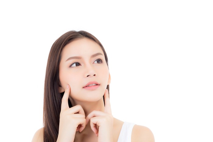 945363202 Portrait of beautiful asian woman makeup of cosmetic, girl hand touch cheek and smile attractive, face of beauty perfect with wellness isolated on white background with skin healthcare concept.