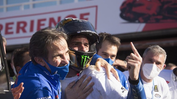 VALENCIA, SPAIN - NOVEMBER 15: Joan Mir of Spain and Team Suzuki ECSTAR  celebrates with Davide Brivio (L) of Italy and Team Suzuki MotoGP  the victory of 2020 championship of MotoGp season under the podium at the end of the MotoGp race during the MotoGP of Comunitat Valenciana at Comunitat Valenciana Ricardo Tormo Circuit on November 15, 2020 in Valencia, Spain. (Photo by Mirco Lazzari gp/Getty Images)