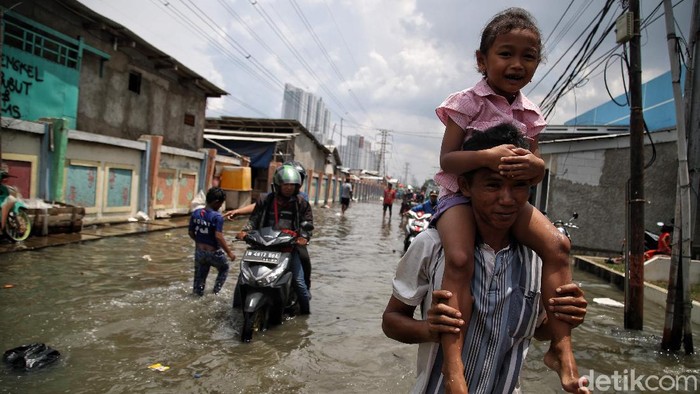 Banjir rob merendam sejumlah rumah warga di kawasan Muara Angke, Jakarta Utara. Tak sedikit warga yang tetap beraktivitas meski dikepung oleh banjir.