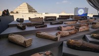 Orang-orang melihat sarkofagus kuno yang dipajang di Saqqara, Giza, Mesir.  