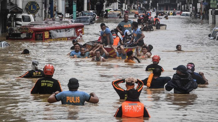 Rescuers pull a rubber boat carrying residents through a flooded street after Typhoon Vamco hit in Marikina City, suburban Manila on November 12, 2020. (Photo by Ted ALJIBE / AFP)