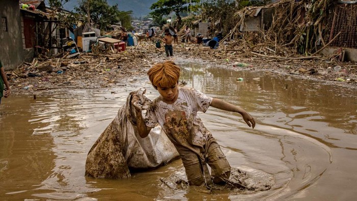 Potret Keganasan Topan Vamco di Filipina RODRIGUEZ, PHILIPPINES - NOVEMBER 14: Residents affected by Typhoon Vamco scuffle over relief goods on November 14, 2020 in Rodriguez, Rizal province, Philippines. Thick mud and debris have covered many villages in the Philippine capital and surrounding provinces after Typhoon Vamco caused widespread flooding which sent people fleeing to their roofs and killed at least 39 people. (Photo by Ezra Acayan/Getty Images)