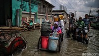 Tak sedikit warga yang memilih untuk tetap mencari nafkah di tengah banjir rob yang merendam kawasan Muara Angke.