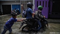 Meski jalan yang berada di kawasan Muara Angke tampak terendam banjir, sejumlah kendaraan tampak nekat melintasi jalan tersebut. Tak heran, beberapa kendaraan tersebut pun mogok hingga dibantu oleh warga untuk melintasi jalan yang terendam banjir.