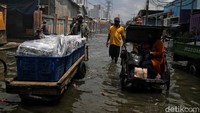 Tak heran, meski jalan di kawasan itu terendam banjir, sejumlah warga masih tampak hilir mudik beraktivitas melintasi jalan tersebut.