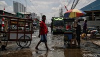 Sejumlah pedagang makanan berjualan di area yang tergenang di kawasan Muara Angke, Jakarta Utara.