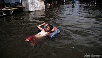 Banjir rob yang merendam kawasan Muara Angke, Jakarta Utara, menjadi hiburan tersendiri bagi anak-anak di area tersebut.