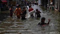 Sejumlah anak tengah asyik berenang dan bermain air saat banjir rob merendam kawasan tempat tinggal mereka di Muara Angke, Jakarta Utara, Senin (16/11/2020).