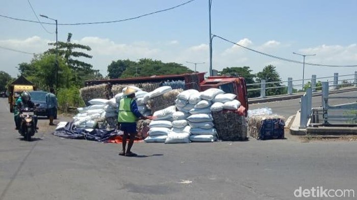 Truk muat plastik terguling saat naik flyover di Desa Masangan, Sukodono, Sidoarjo. Kecelakaan itu membuat muatan tumpah di jalan dan sopir mengalami luka-luka.