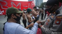 Di tengah pandemi corona, petugas yang memantau aksi demo juga membagikan masker kepada para mahasiswa.
