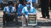 Meski demo, mereka tetap mengutamakan protokol kesehatan dengan mengenakan masker.