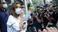 Ia pun tampak sibuk merapihkan maskernya dan memilih untuk berlalu dari kerumunan awak media. Pool/Palevi S/detikFoto.