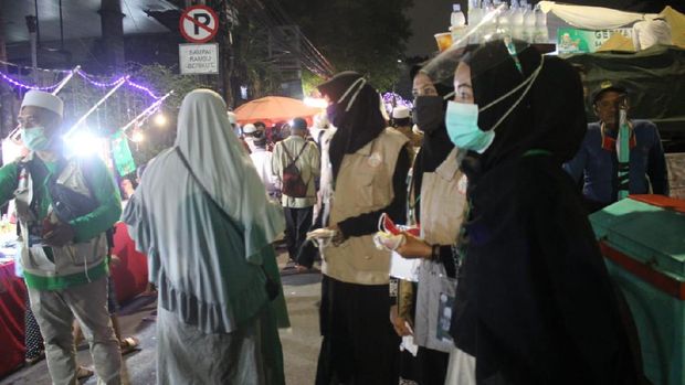 Panitia acara Habib Rizieq membagi-bagikan masker ke tamu yang hadir, Petamburan, Jakarta Pusat, Sabtu (14/11/2020).