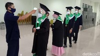 Sebelum masuk ke gedung tersebut wisudawan menerapkan protokol kesehatan. Seperti dites suhu terlebih dahulu, mencuci tangan, mengenakan masker, hingga harus berjarak.