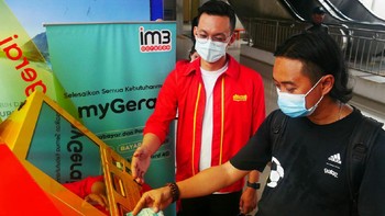VP-Head of Retail Channel Development Indosat Ooredoo, Roswida Sidauruk saat memberikan edukasi kepada pelanggan (kanan) yang ingin menggunakan mesin MyGerai di Stasiun Tanah Abang, Jakarta, Selasa (17/11).  