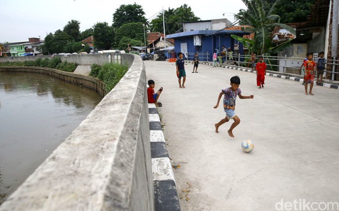Jalan inspeksi Ciliwung di kawasan Bukit Duri, Jakarta, dimanfaatkan sejumlah anak untuk bermain sepakbola. Hal itu terpaksa dilakukan karena minimnya lahan bermain.