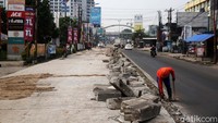 Pekerja melakukan proses perbaikan jalan Joyo Martono arah Bulak Kapal ke tol Bekasi Timur, Kota Bekasi, Jawa Barat, Rabu (18/11/2020).