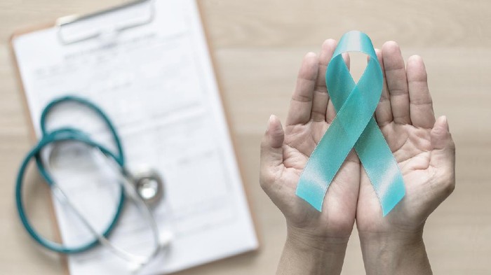 Teal ribbon awareness on womans hand for Ovarian Cancer, Polycystic Ovary Syndrome (PCOS) disease, Post Traumatic Stress Disorder (PTSD), Tourettes Syndrome, Obsessive Compulsive Disorder (OCD)
