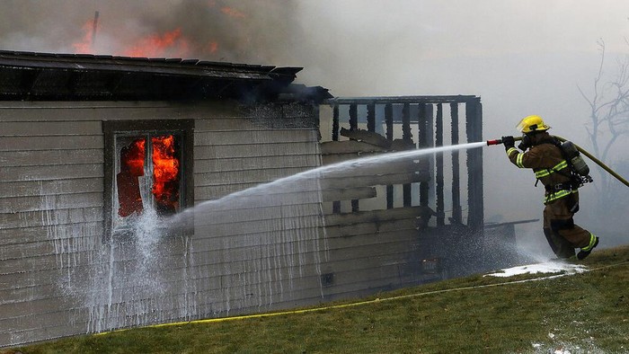 Kebakaran Hutan Nevana Mulai Merambat ke Pemukiman Warga A firefighter tries to put out the final flames of a burned home during the Pinehaven Fire in the Caughlin Ranch area of Reno, Nev., on Tuesday, Nov. 17, 2020. (Jason Bean/The Reno Gazette-Journal via AP)