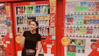 Liburan ke Jepang, Millen berpose manis di depan vending machine yang menjual aneka minuman ringan. Foto: Instagram @millencyrus