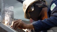 Pekerja tampak mengelas potongan-potongan besi dalam proses pembangunan JPO.