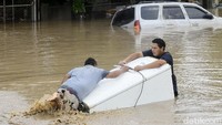 Badai lota menghantam kota Lima. Tampak dua orang sedang mengevakusi lemari es miliknya. Yoseph Amaya/Getty Images.