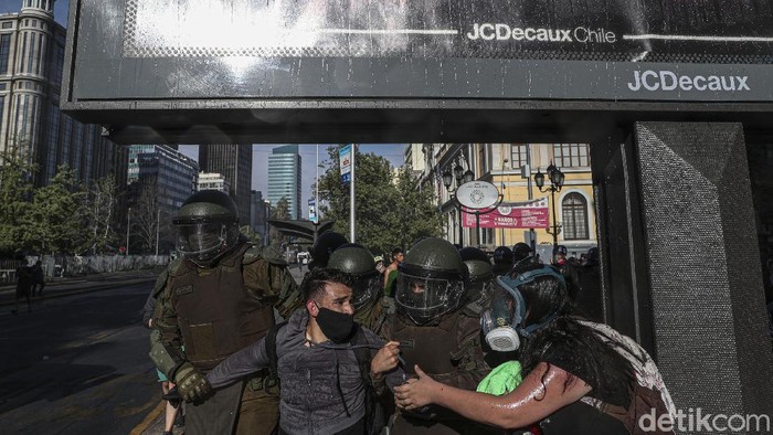 Ratusan orang melakukan aksi protes di Santiago, ibu kota Chile, pada Rabu (18/11) untuk menuntut pengunduran diri Presiden Sebastian Pinera. Tuntutan itu muncul atas praktik penindasan polisi terhadap aksi protes soal masalah sosial di negara itu.