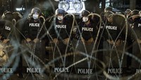 Polisi membentuk barikade di belakang kawat berduri yang dipasang di sekitar kantor polisi. AP Photo/Wason Wanichakorn.