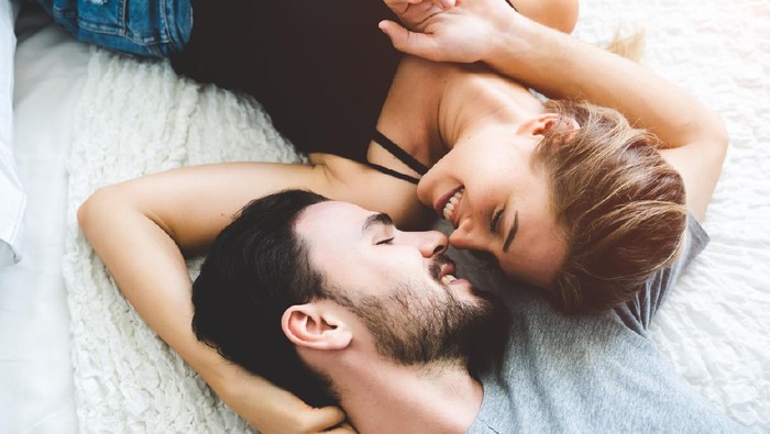 ilustrasi seks Passionate woman gently kissing man on with romantic kiss.desire lying on bed, young tender lover enjoys touching soft skin of sensual sexy lady moaning having sex.