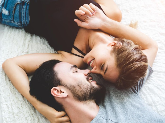 Passionate woman gently kissing man on with romantic kiss.desire lying on bed, young tender lover enjoys touching soft skin of sensual sexy lady moaning having sex.