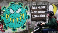 Mural yang menghiasi dinding itu bergambar bentuk virus COVID-19.