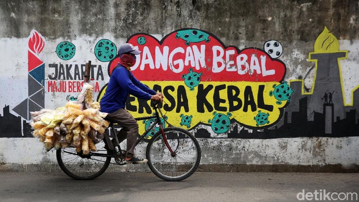 Mural COVID-19 Sarana Edukasi Masyarakat Pengendara melintasi mural bertema COVID 19 di Jalan Cakung Cilincing Barat, Jakarta Timur, Kamis (19/11/2020). Mural masih dianggap menjadi sarana edukasi kesehatan yang tepat bagi warga untuk menjaga diri dari penularan virus Covid 19.