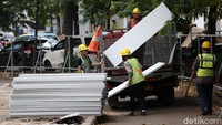 Para pekerja menurunkan berbagai material bangunan.