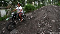Seorang warga melintasi jalan yang rusak di kawasan Klaten, Jawa Tengah, Jumat (20/11/2020).