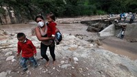 Warga yang ingin melintas harus melewati tangga dan berjalan melalui reruntuhan jembatan.
