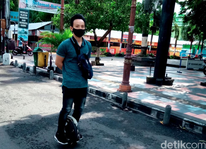 Aldo Jonathan (32) mengendarai kendaraan listrik satu roda untuk berangkat kerja. Kendaraan listrik tersebut jadi salah satu solusi untuk kurangi polusi udara.