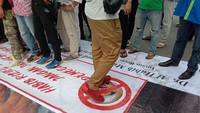 Di tengah aksi yang digelar di depan kantor Gubernur Sumut, Jumat (20/11) lalu itu spanduk yang berisi foto Habib Rizieq tampak diinjak massa. Dok. Detikcom.