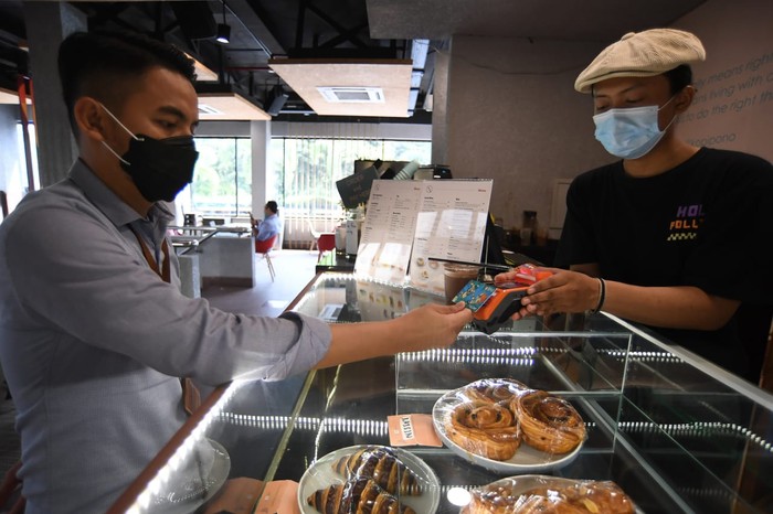 Pengunjung sebuah cafe sedang bertransaksi menggunakan kartu BNI TapCash