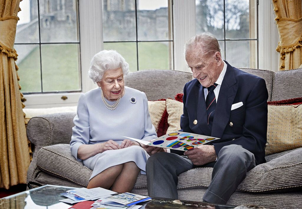 In this image released on Thursday Nov. 19, 2020, Britain's Queen Elizabeth II and Prince Philip, Duke of Edinburgh look at a homemade wedding anniversary card, given to them by their great grandchildren Prince George, Princess Charlotte and Prince Louis, as the royal couple sit in the Oak Room at Windsor Castle, England, Nov. 17, 2020, ahead of their 73rd wedding anniversary.  Elizabeth married Philip on Nov. 20, 1947, at Westminster Abbey in London. Prince George, Princess Charlotte and Prince Louis are the children of Prince William and Catherine, Duchess of Cambridge, and great-grandchildren to Queen Elizabeth and Prince Philip. (Chris Jackson/Pool via AP)