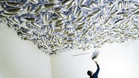 Para pekerja meletakkan sentuhan akhir pada instalasi Peluru Ajaib karya seniman General Idea di Museum of Modern Art (MoMa).